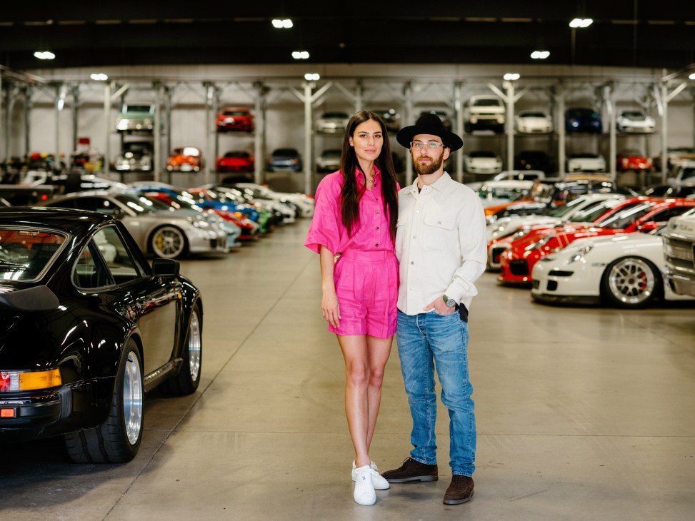 Morgan Reed and Eli Kogan of Otto Car Club standing among luxury sports cars in warehouse
