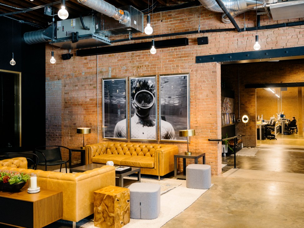 Dialexa office interior with exposed brick walls, industrial ceiling, modern furniture and artwork