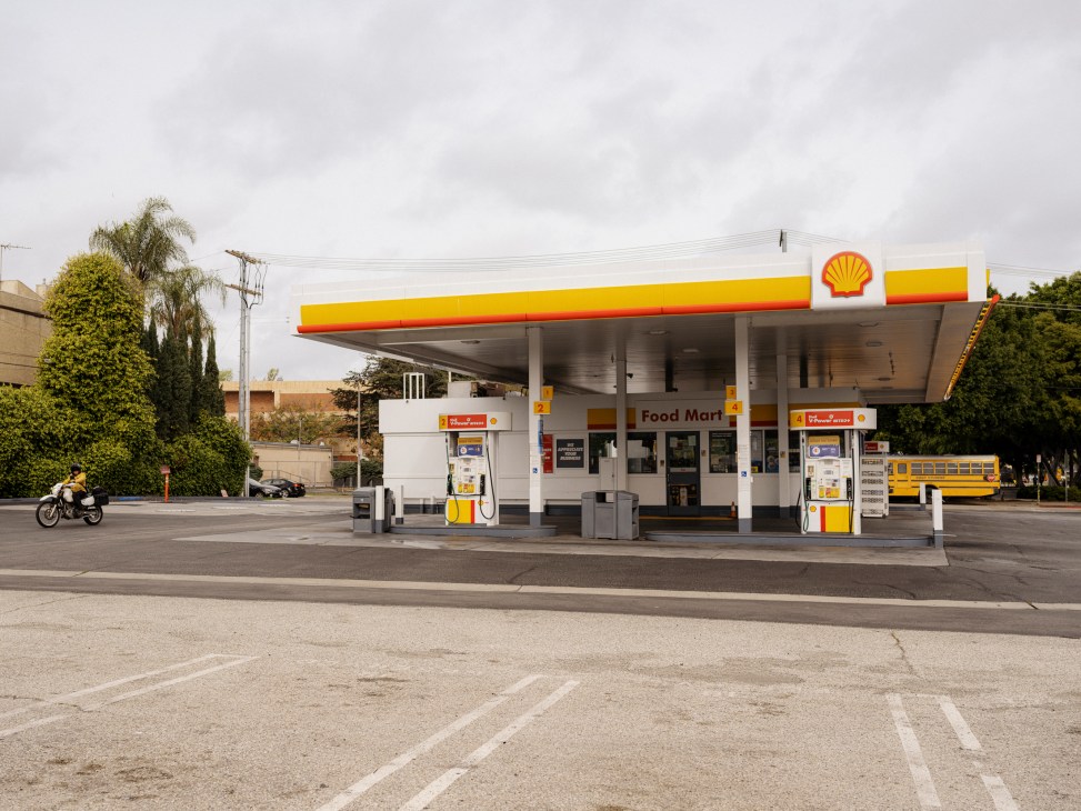 Shell gas station with yellow and red canopy, fuel pumps, and Food Mart convenience store