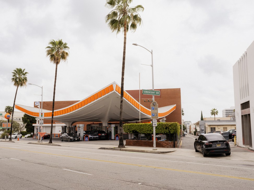 Mid-century modern gas station with distinctive angular orange and white canopy and brick facade