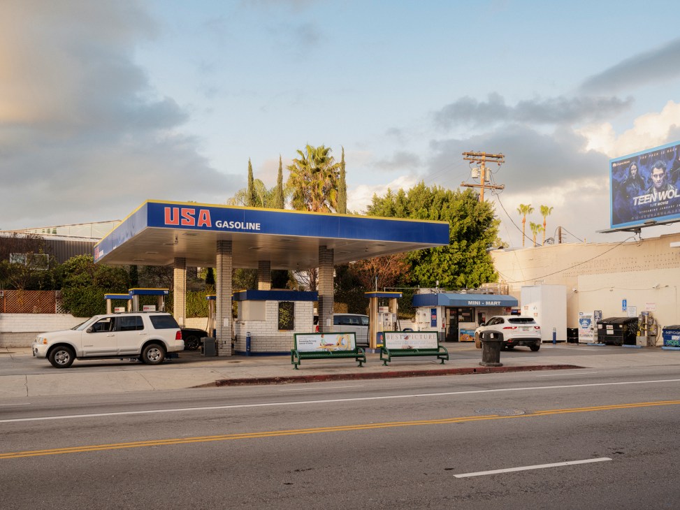 USA Gasoline station with white SUV parked under canopy, convenience store attached