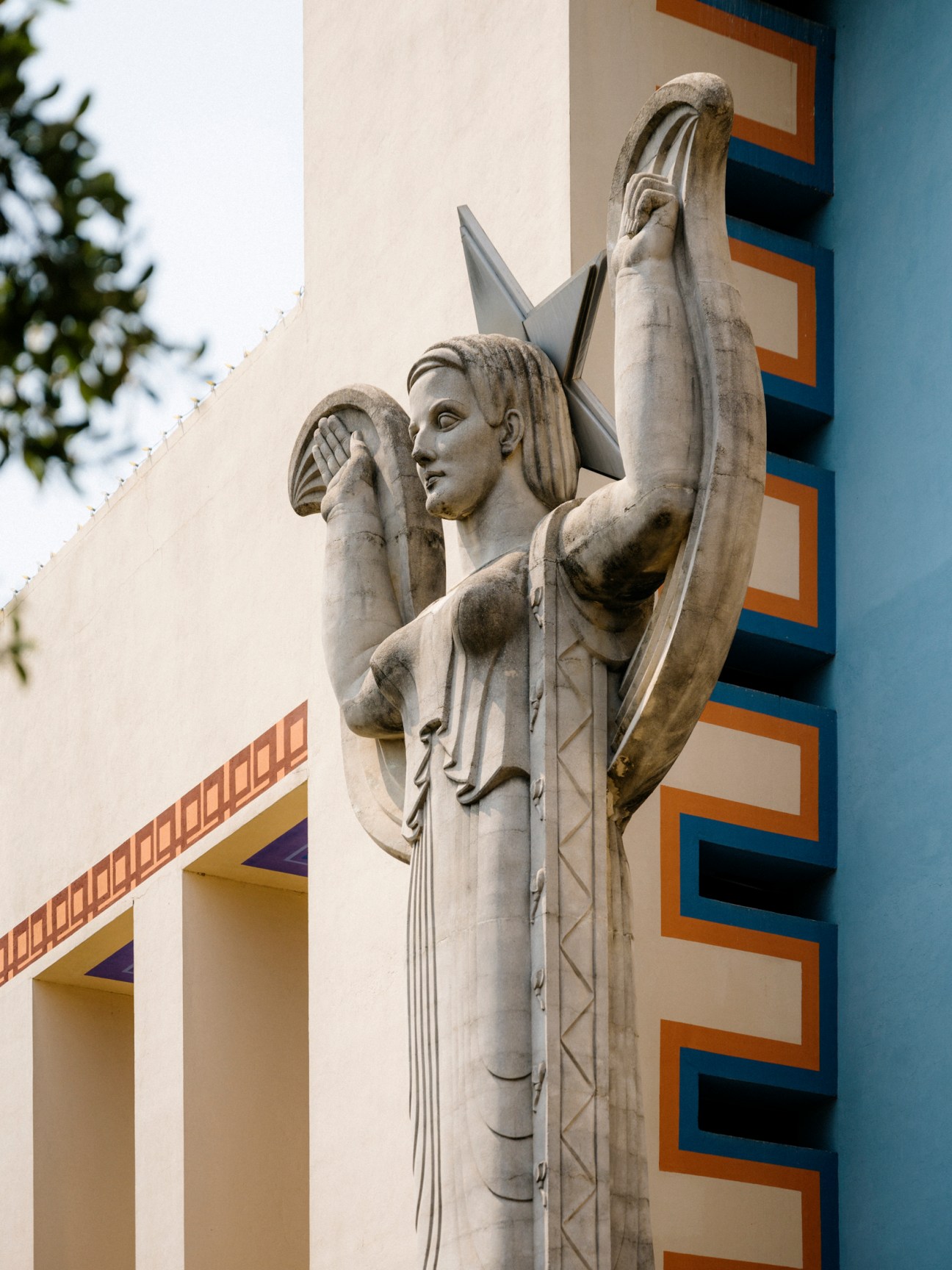 Art deco statue of a winged figure holding objects at Fair Park in Dallas