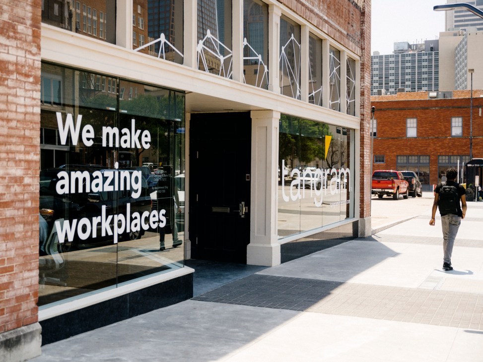 Tangram storefront with glass windows displaying 'We make amazing workplaces' text and geometric logo design