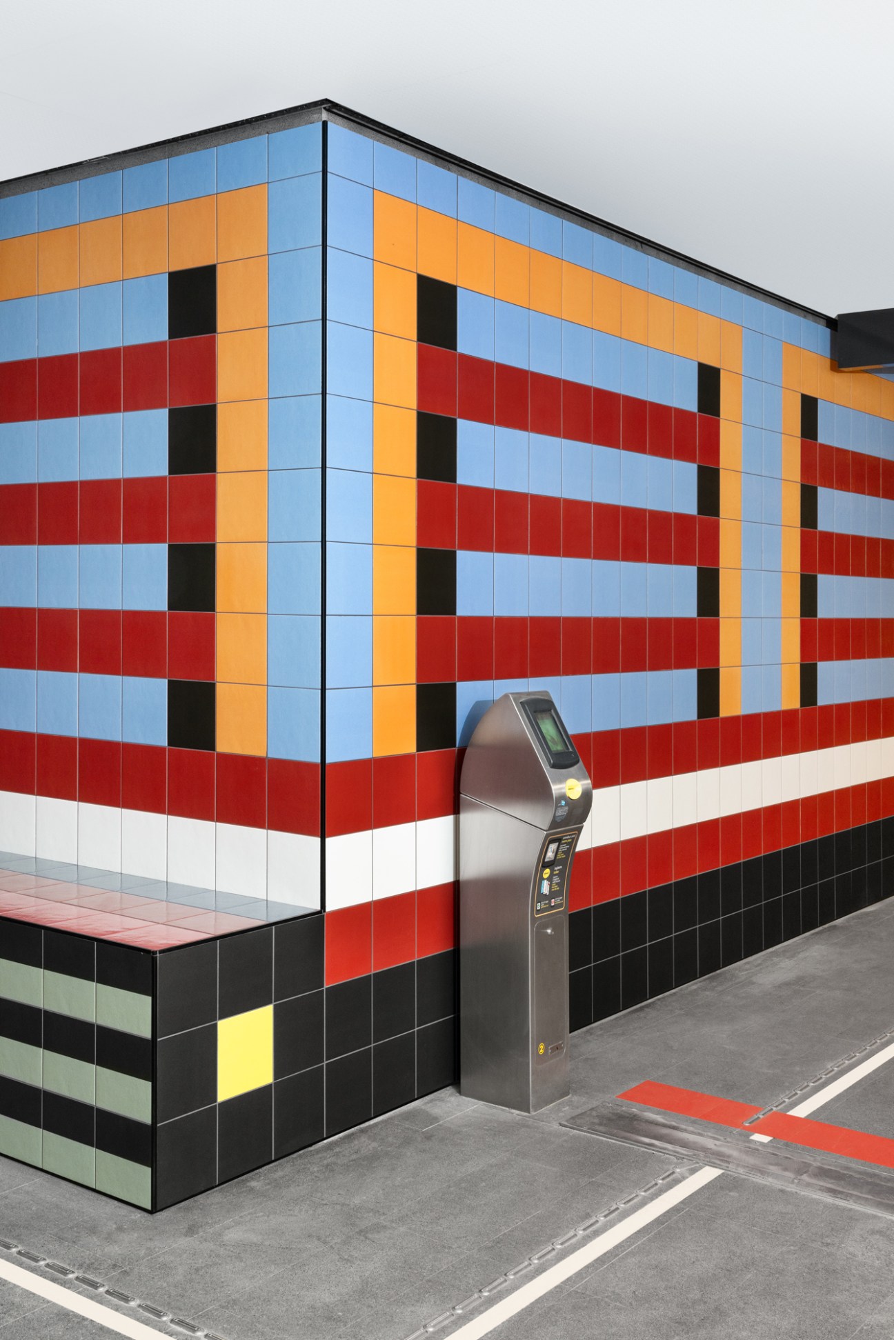 Colorful geometric tile installation by Nathalie du Pasquier at Brescia metro station with built-in bench