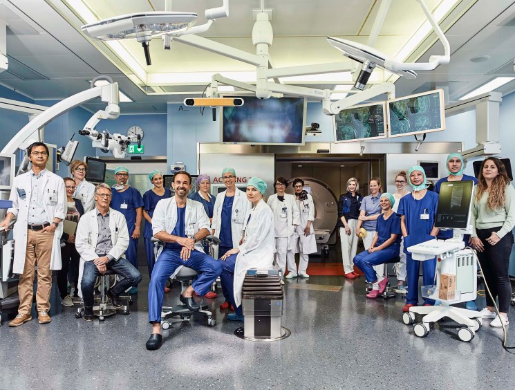 Neurosurgical oncology team at University Hospital of Bern posing together in an operating room