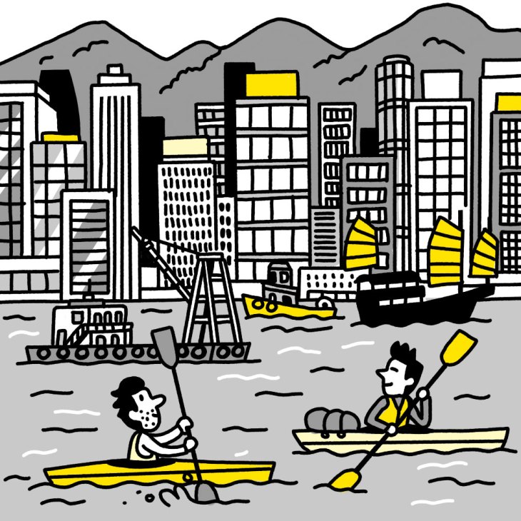 Two people kayaking in yellow boats near a city skyline with mountains in the background