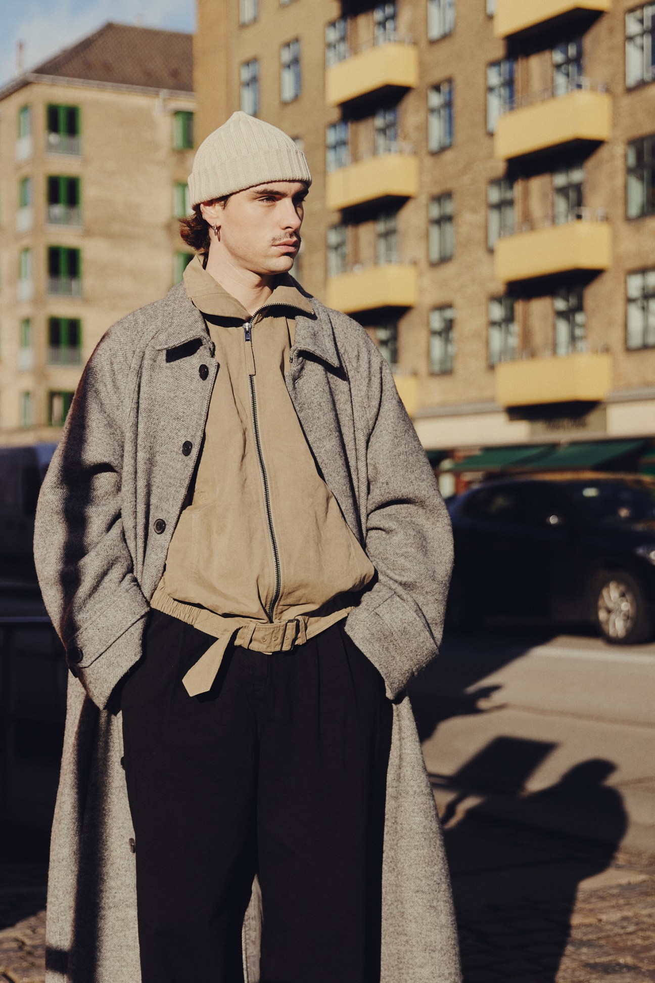 Stylishly dressed person in colorful casual outfit with tote bag during Copenhagen fashion week