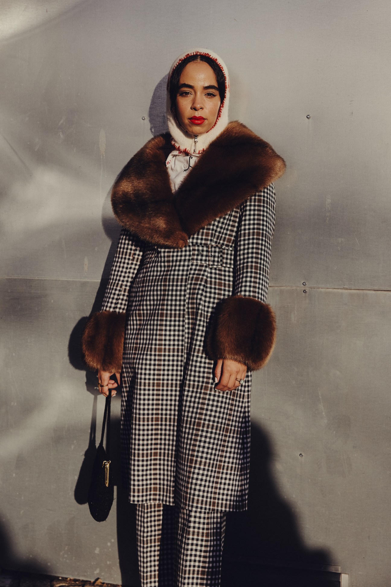 Fashion week attendee in elegant long coat and boots walking on Copenhagen street