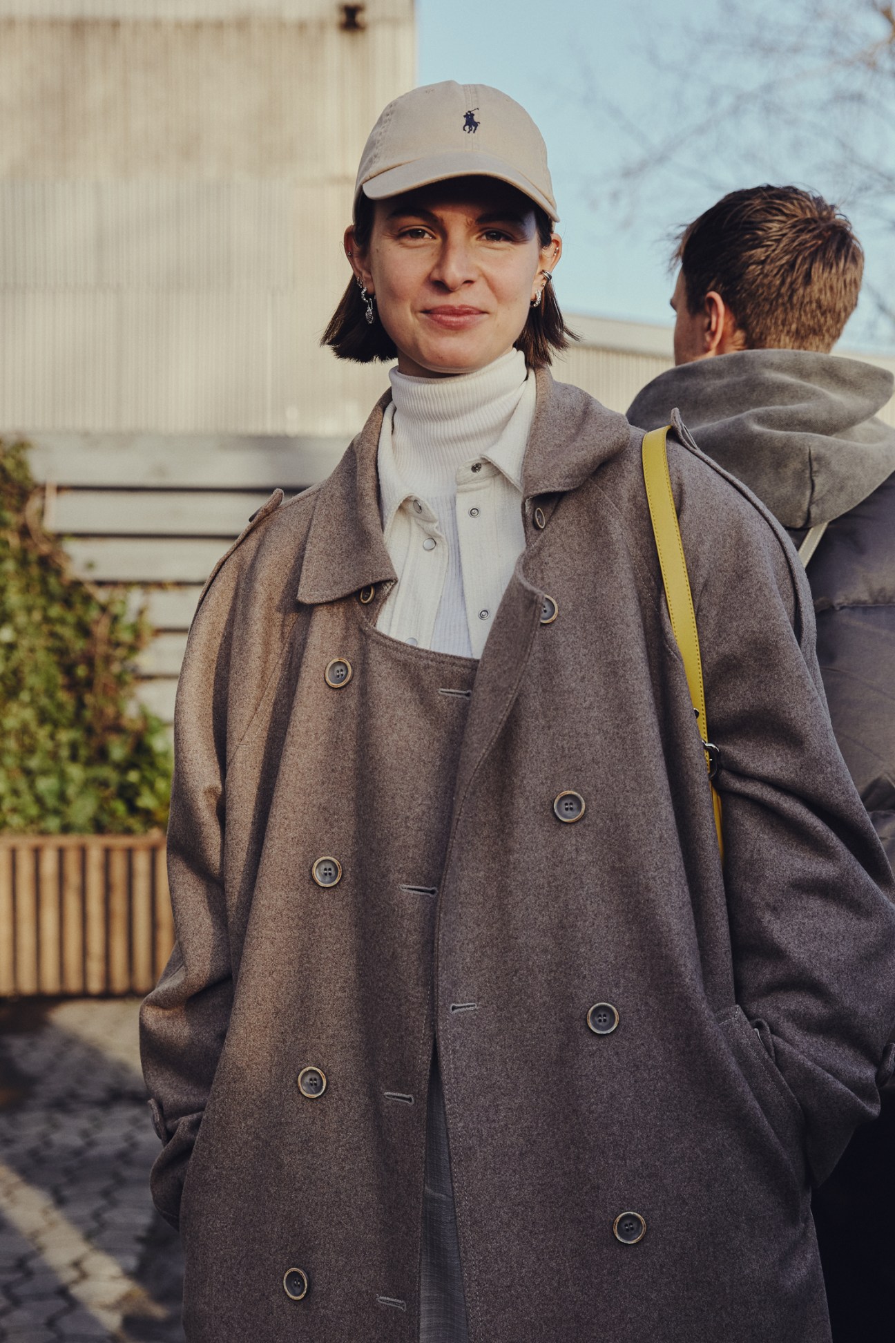 Person wearing contemporary Danish fashion including structured outerwear on Copenhagen street during fashion week