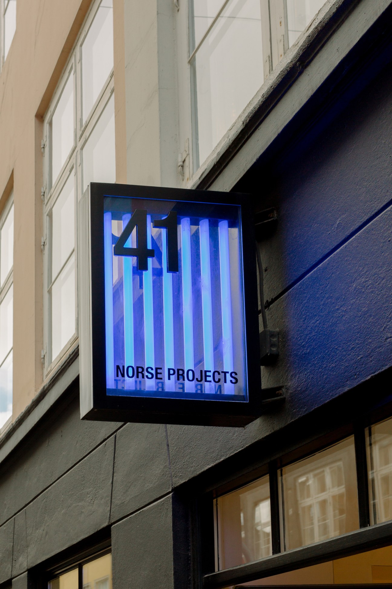 Illuminated blue sign displaying '451' and 'NORSE PROJECTS' mounted on building exterior