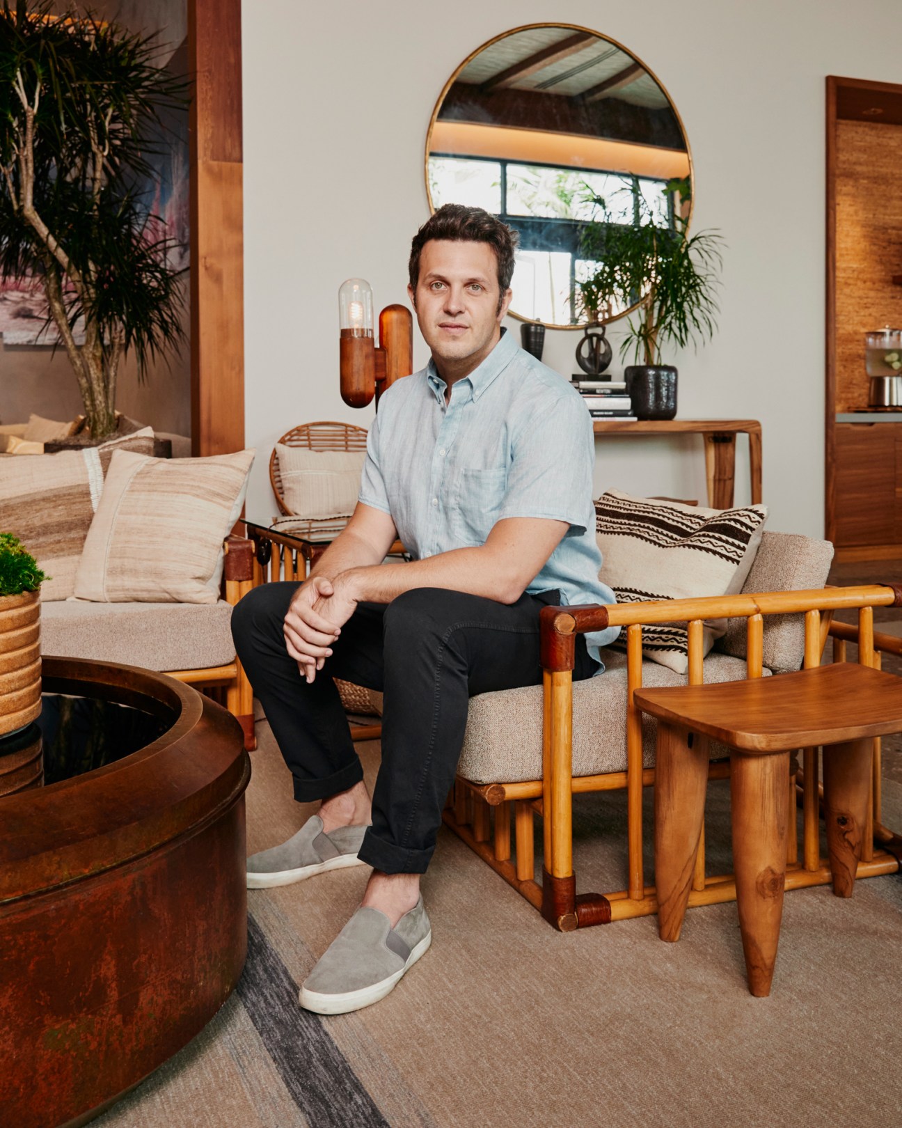 Marketing and brand director Jason Katz sitting in modern hotel interior with mid-century furniture and round mirror