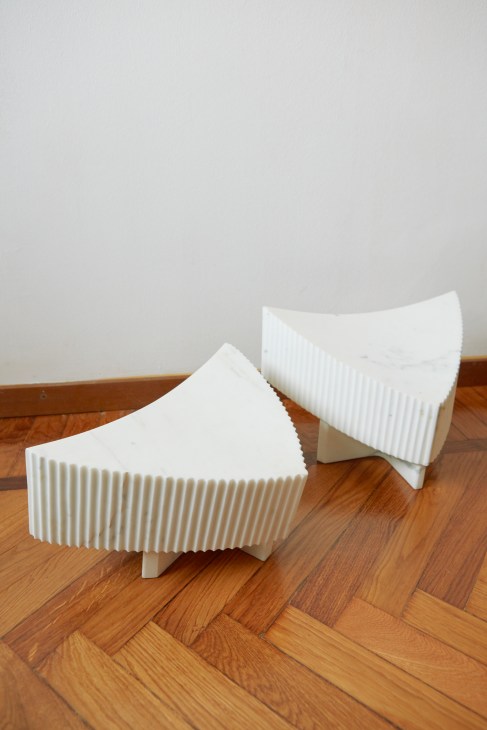 Two white ribbed sculptural marble lamps by Older displayed on wooden flooring.