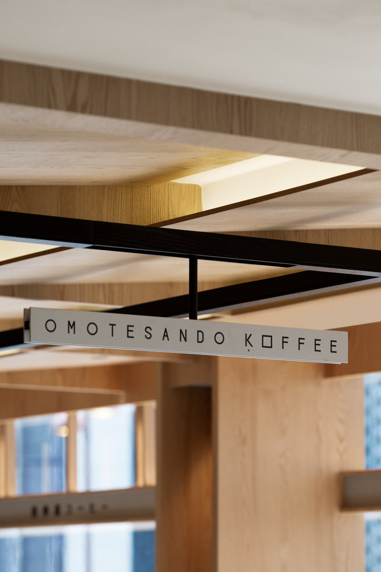Interior detail of Omotesando Koffee showing wooden ceiling beams and built-in seating with natural timber finishes