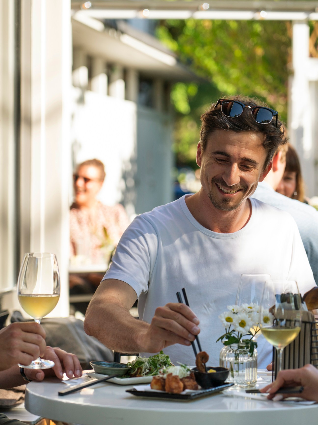 Man dining at Ooki Pavilion terrace with wine glass and Japanese dishes