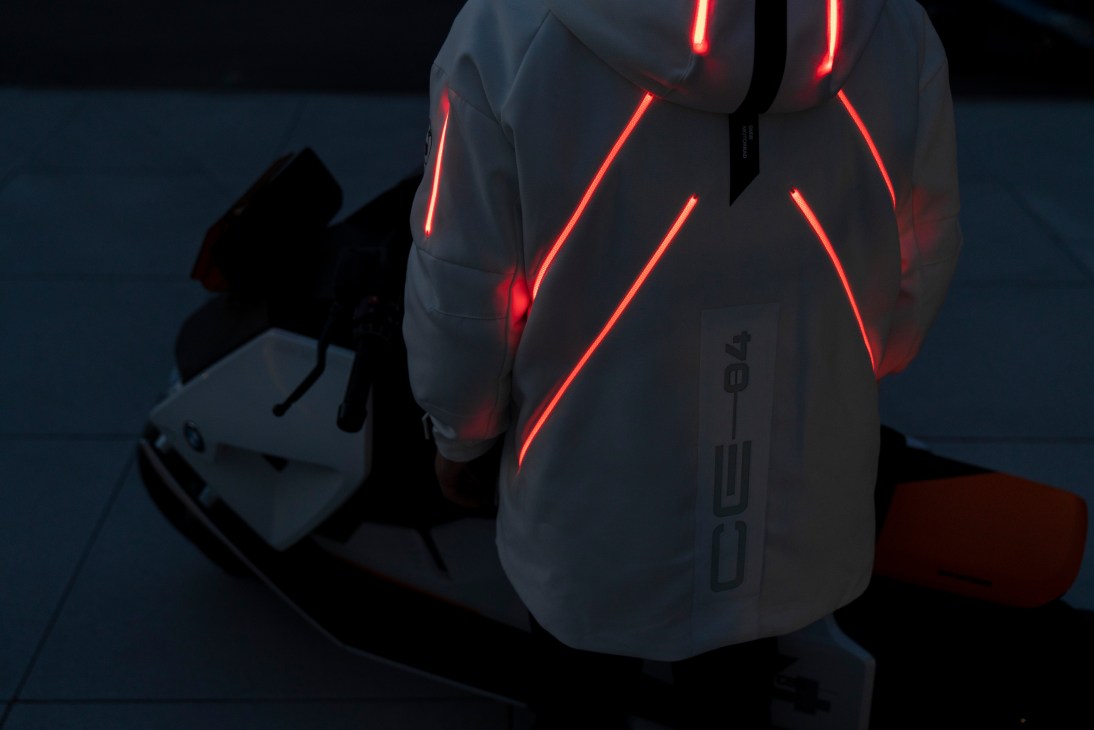 BMW Definition Motorrad CE 04 electric scooter with illuminated red neon-style design elements on dark background.