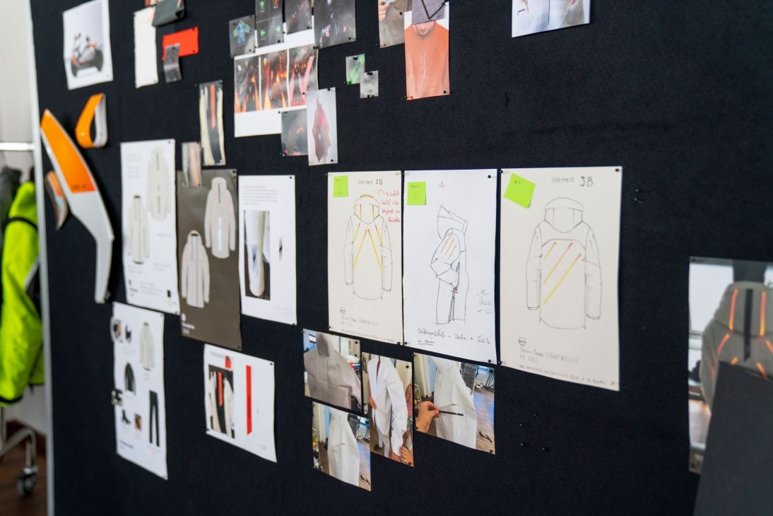 Design studio wall displaying BMW Motorrad CE 04 scooter sketches, prototypes, and development process materials.