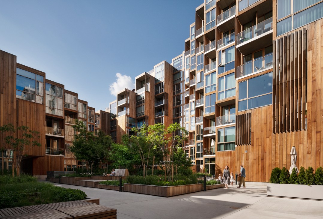 Paulina Pereaux and her family standing in the plant-filled central courtyard of 79&Park apartment building in Stockholm.