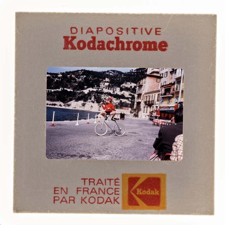 Vintage Kodachrome slide box showing Mediterranean coastal scene with bicycle and buildings