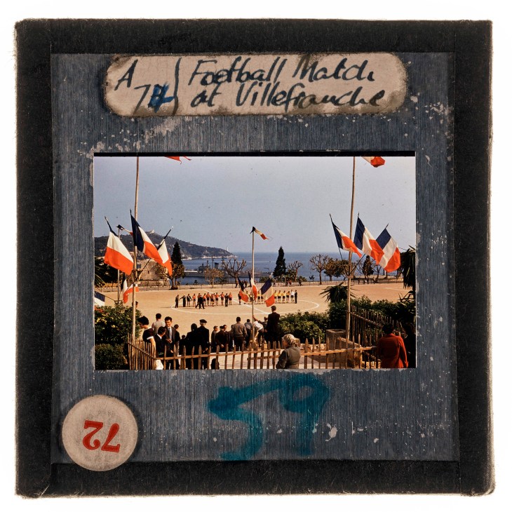Vintage color photograph showing crowds gathered with French flags at a waterfront ceremony in Villefranche
