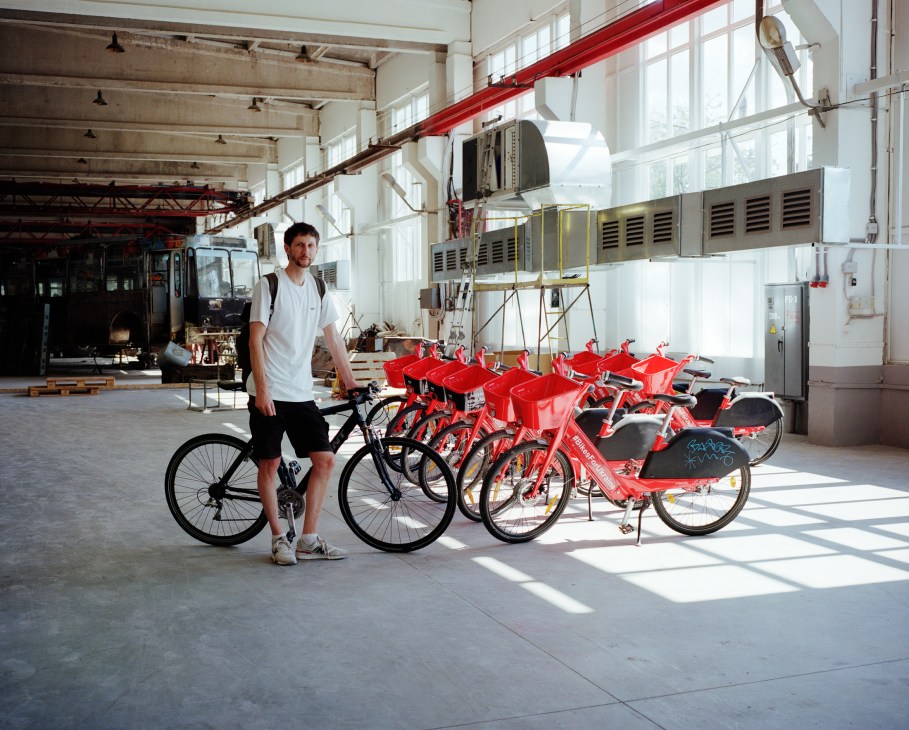 Sergiy Bezborodko standing among donated bicycles at the bike depot