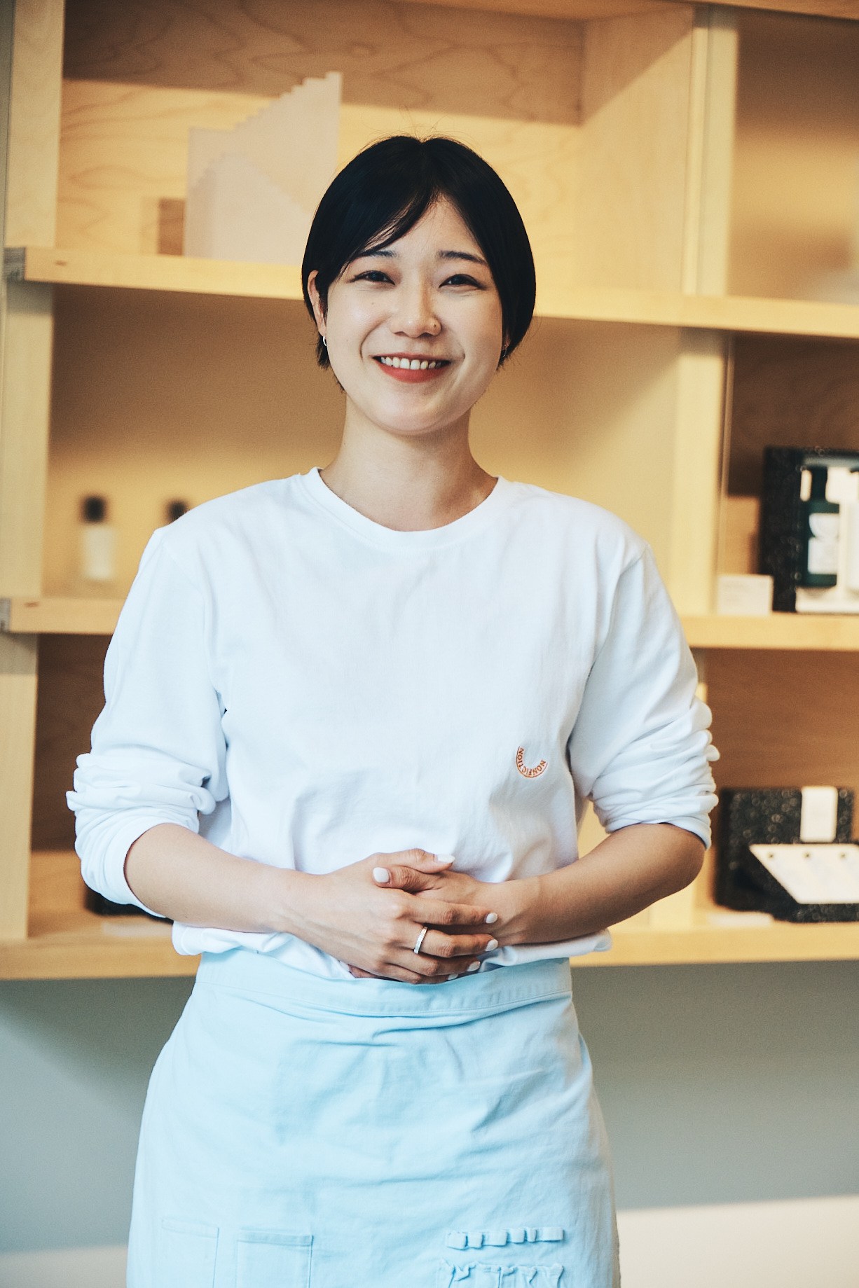 Well turned-out staff member in pale blue uniform at Nonfiction fragrance store
