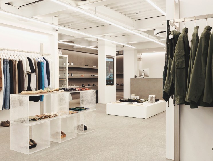 Interior of 8Division menswear store in Seoul showing minimalist white concrete design with clothing racks and displays