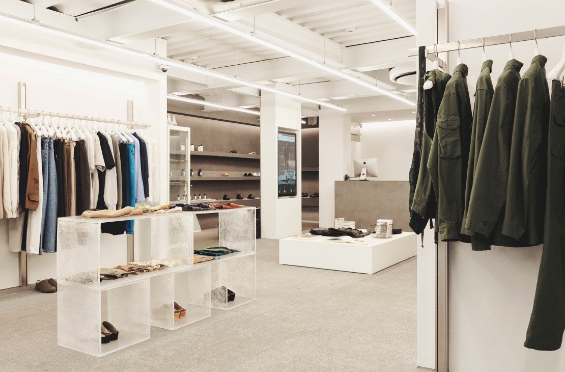 Interior of 8Division menswear store in Seoul showing minimalist white concrete design with clothing racks and displays