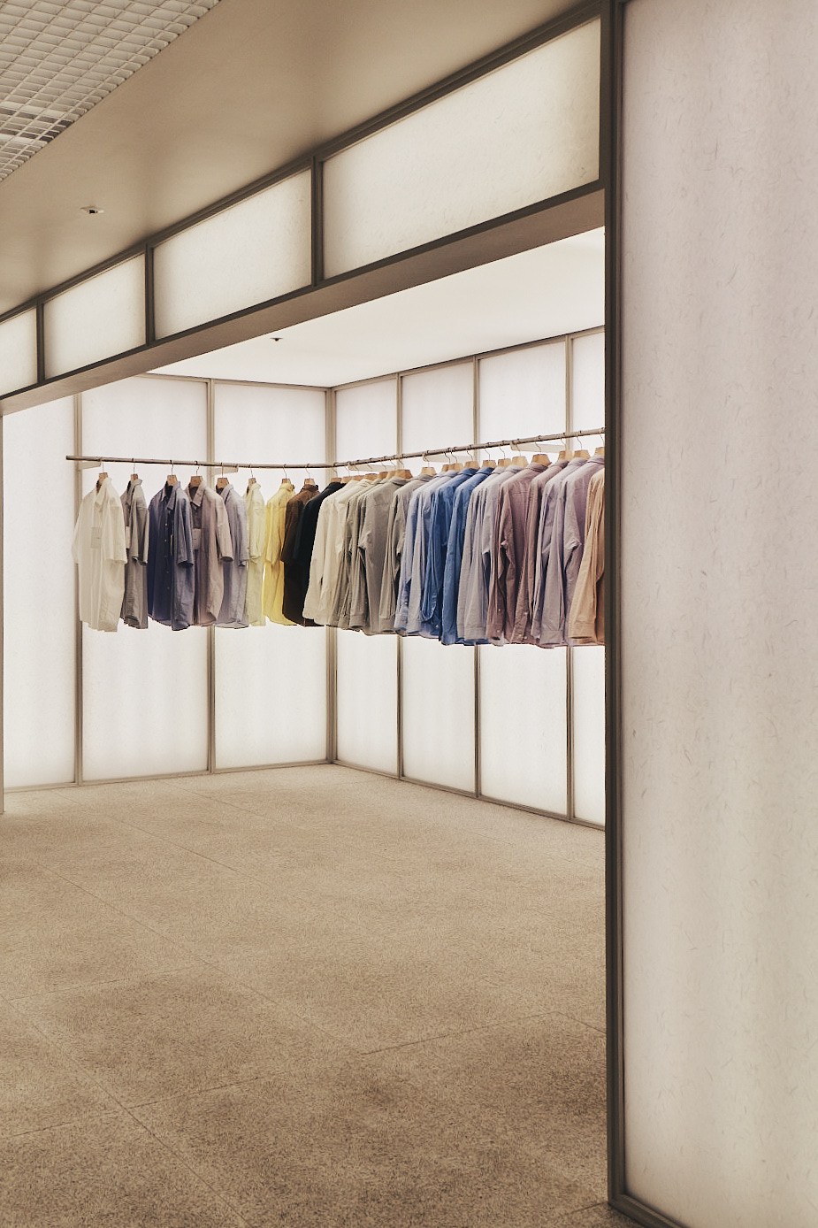 Neatly organized clothing rack displaying various colored garments in a minimalist retail space