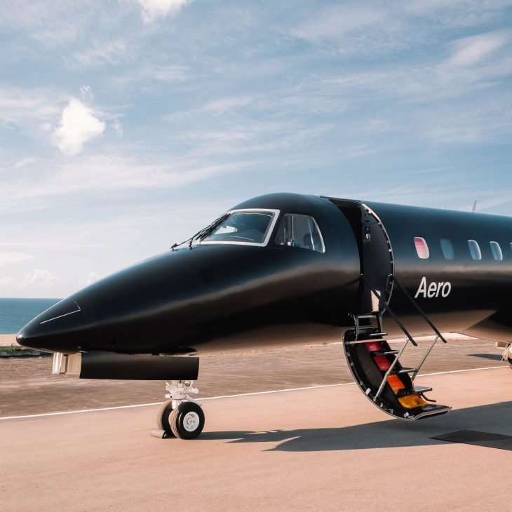 Black Aero aircraft with open door on airport tarmac