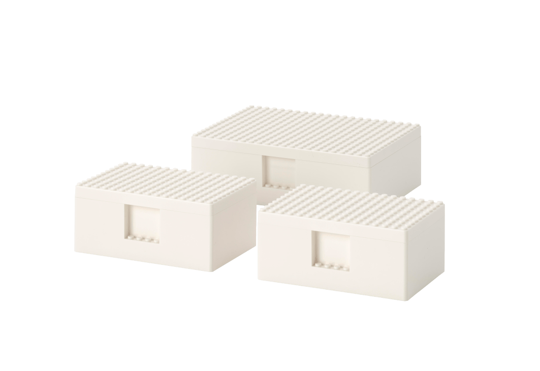 Three white storage boxes with ventilated tops and front openings arranged in a group