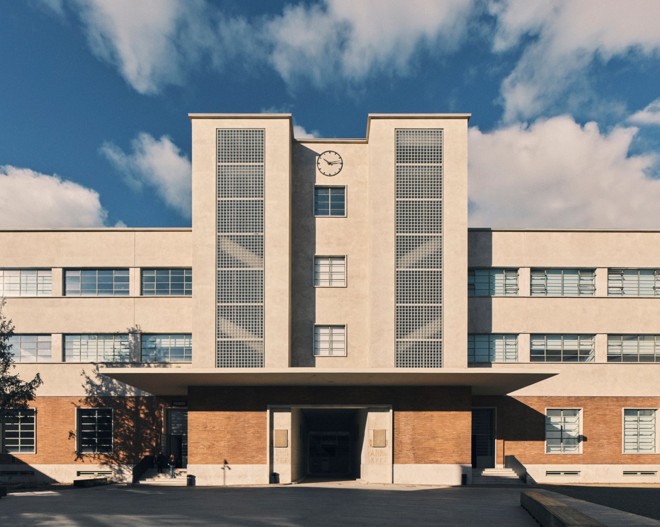 Rationalist architecture building with clock tower and geometric glass block windows at Manifattura Tabacchi