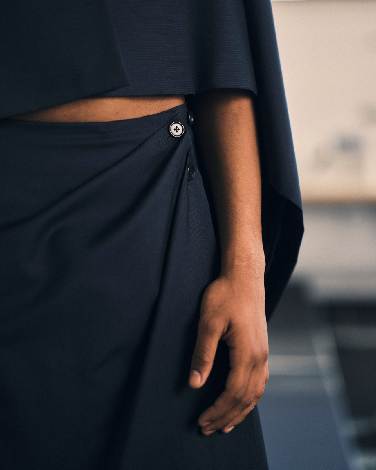 Dark navy garment with wrapped silhouette and button detail from Alvaro Barrera Lozano's collection