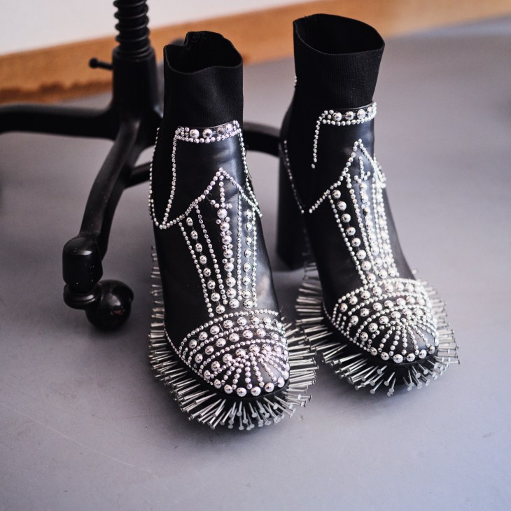 Pair of black high chunky heeled ankle boots embellished with silver nails and studs