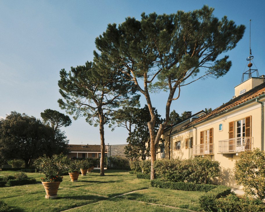 Garden view at Villa Ottolenghi showing Mediterranean pine trees, manicured lawns and historic villa architecture