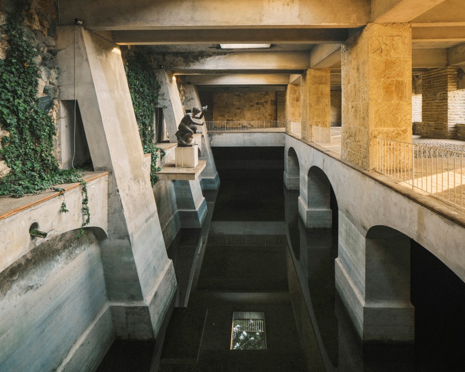 Modernist water cistern with concrete arches and dark water pool at Villa Ottolenghi designed by Pietro Porcinai