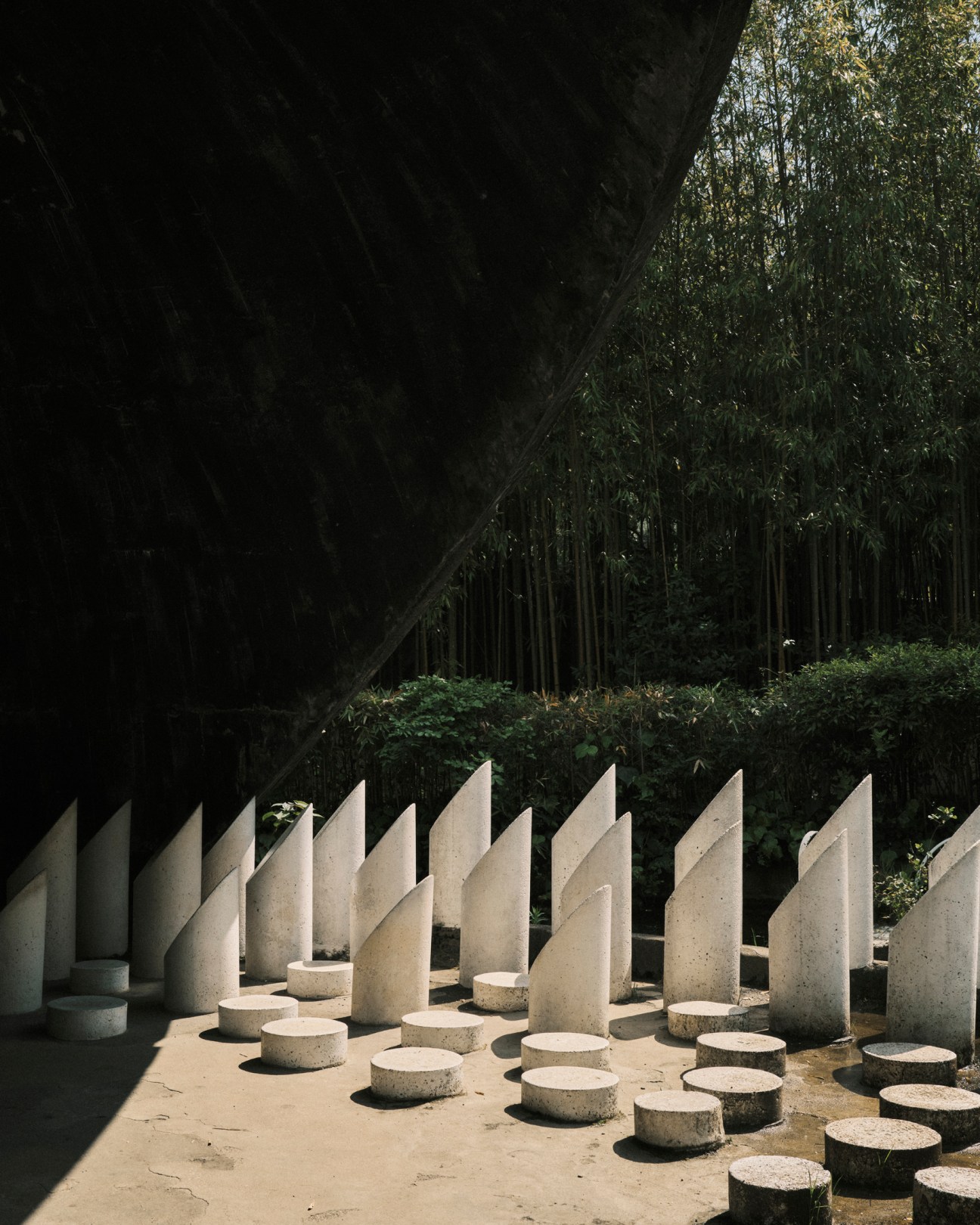Sculptural concrete elements with cylindrical bases and angular vertical forms at Parco di Pinocchio