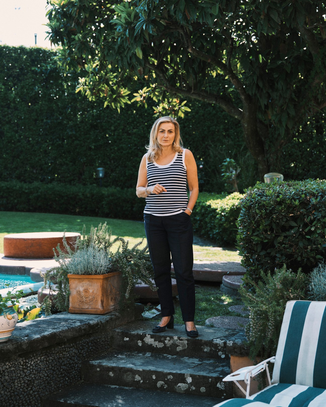 Elisabetta Rangoni standing in modernist garden with circular design elements and structured plantings