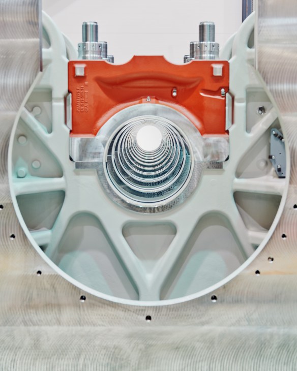 Top-down view of a milled marine engine with red casing, white housing, concentric metal rings, and chrome components.