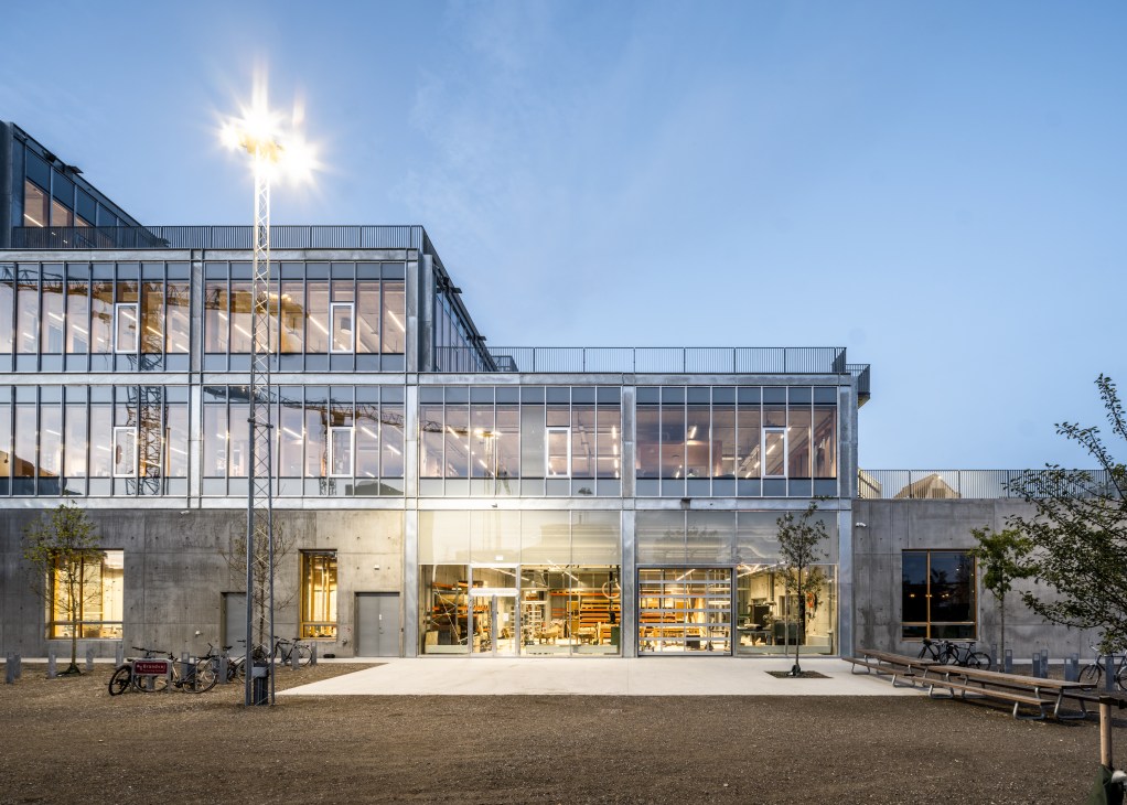Interior view of Aarhus School of Architecture showing glass-walled studios with students working at desks