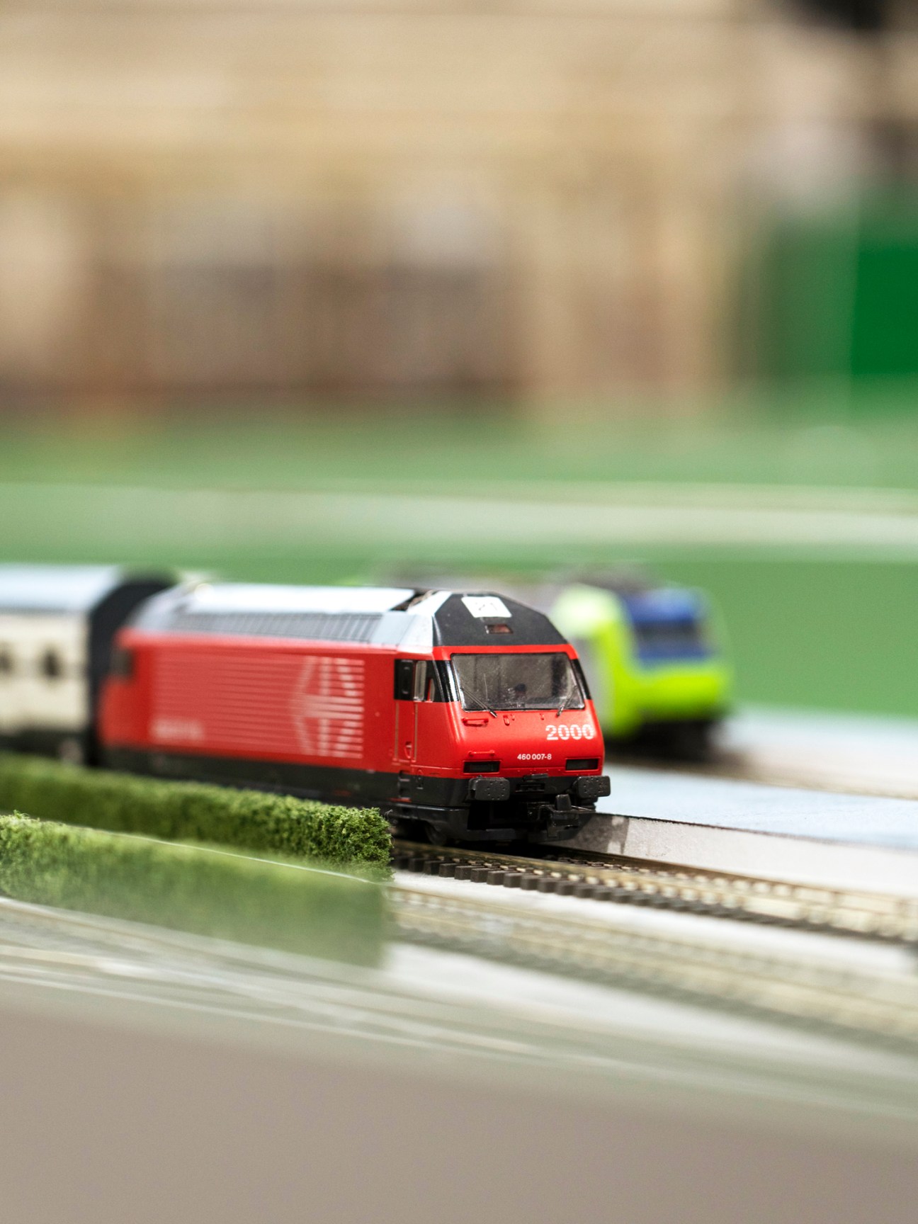 Model intercity train traveling on tracks between miniature stations Zetthausen and Ypslikon