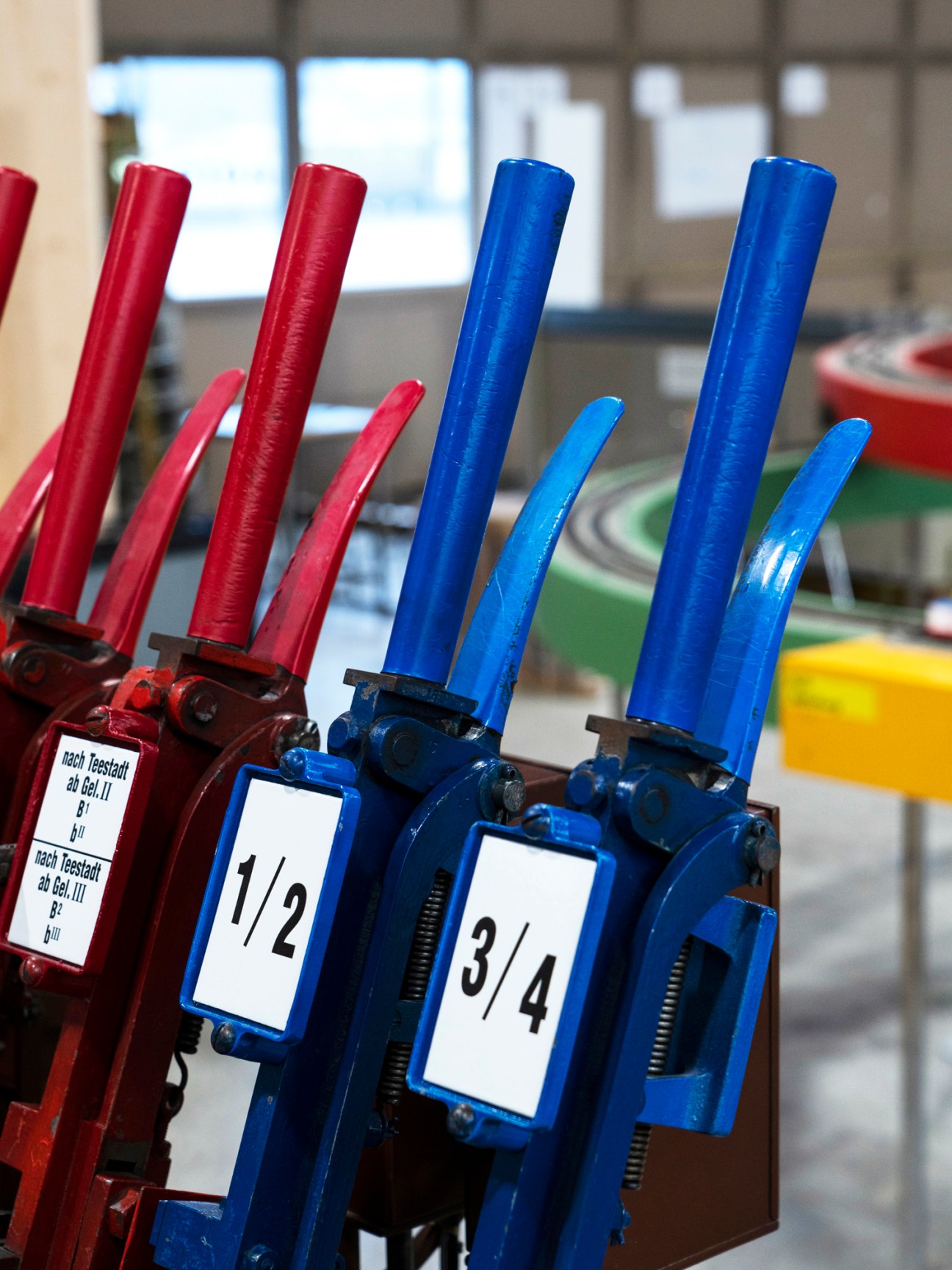 Traditional railway lever frame with multiple red and blue mechanical switches and levers numbered for signal control