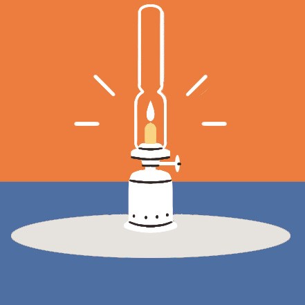 Lit oil lamp with glass chimney and flame on a white circular surface against blue background