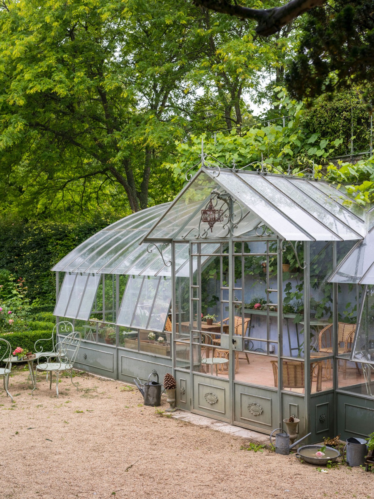 Glass conservatory interior converted to an elegant tea salon with seating and tables