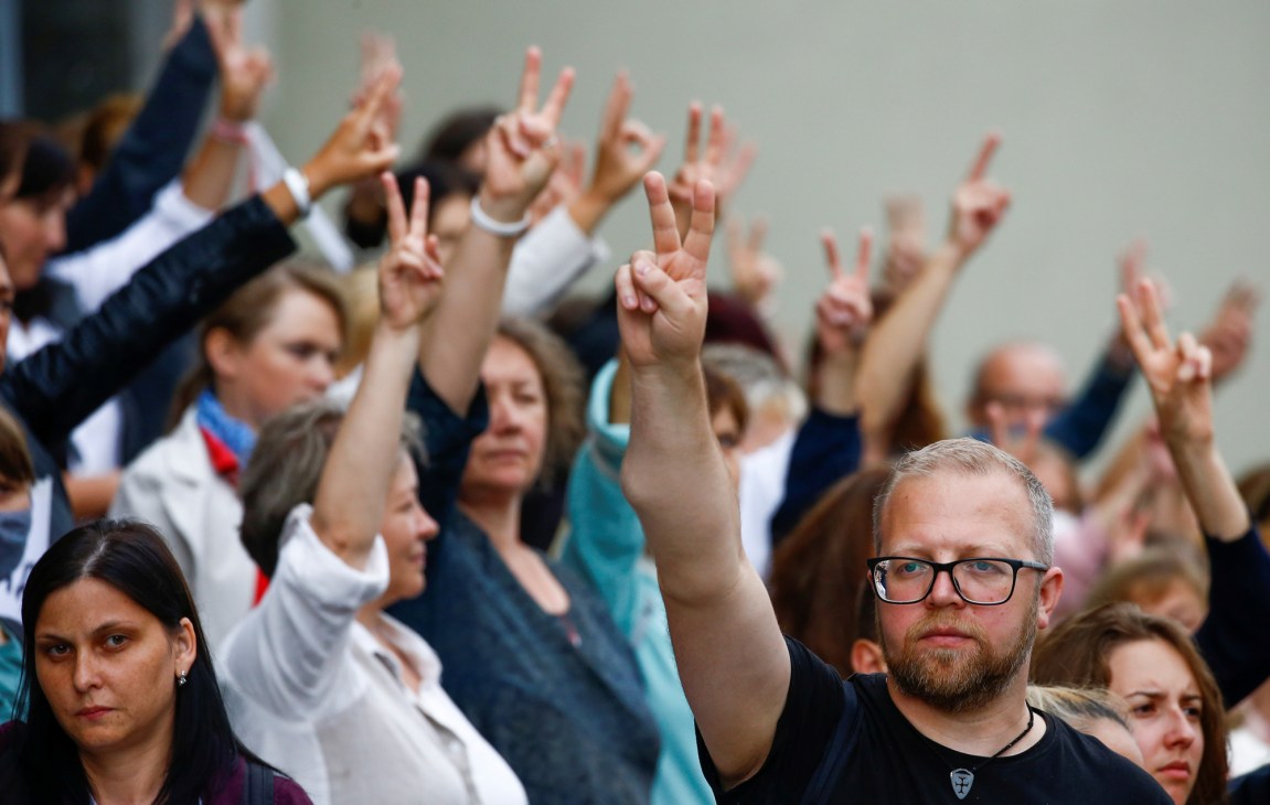 Belarusian protesters making peace signs at a demonstration against election results in Minsk