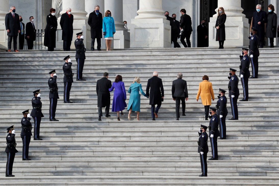 Biden, Harris and their families climbing the steps of the Capitol building