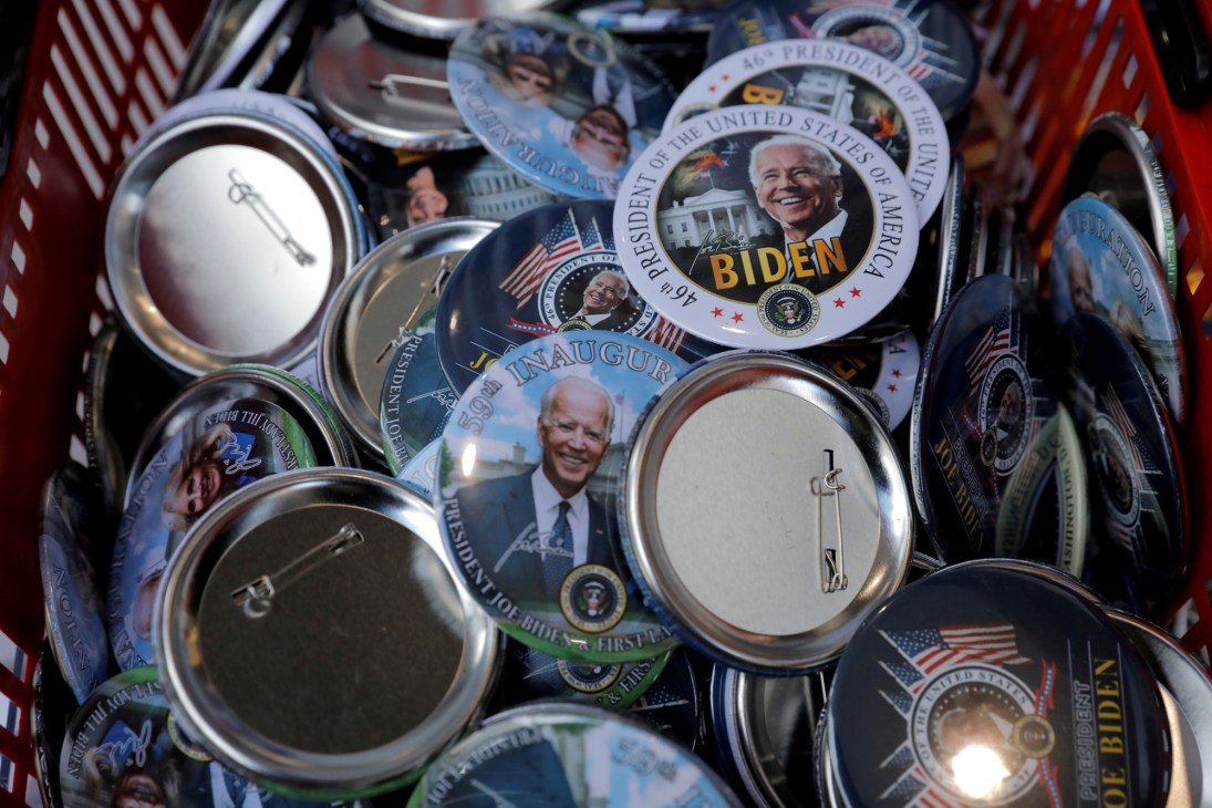 Collection of commemorative badges and buttons featuring Biden as the 46th president