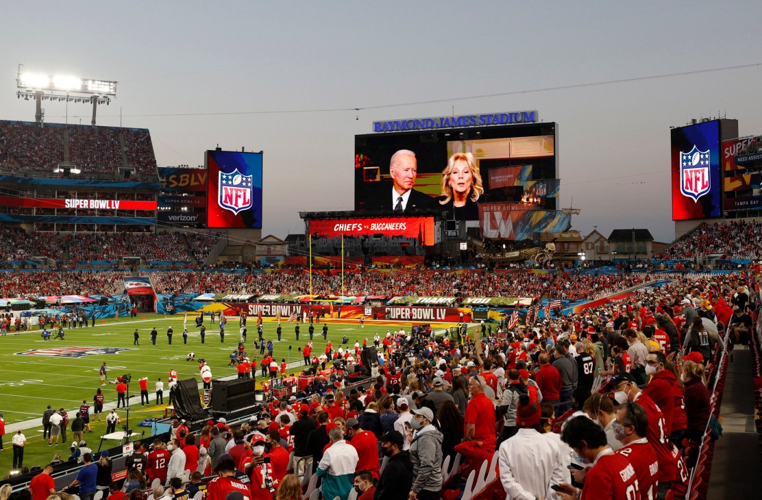 Joe and Jill Biden appearing on a large screen during Super Bowl coverage at Raymond James Stadium