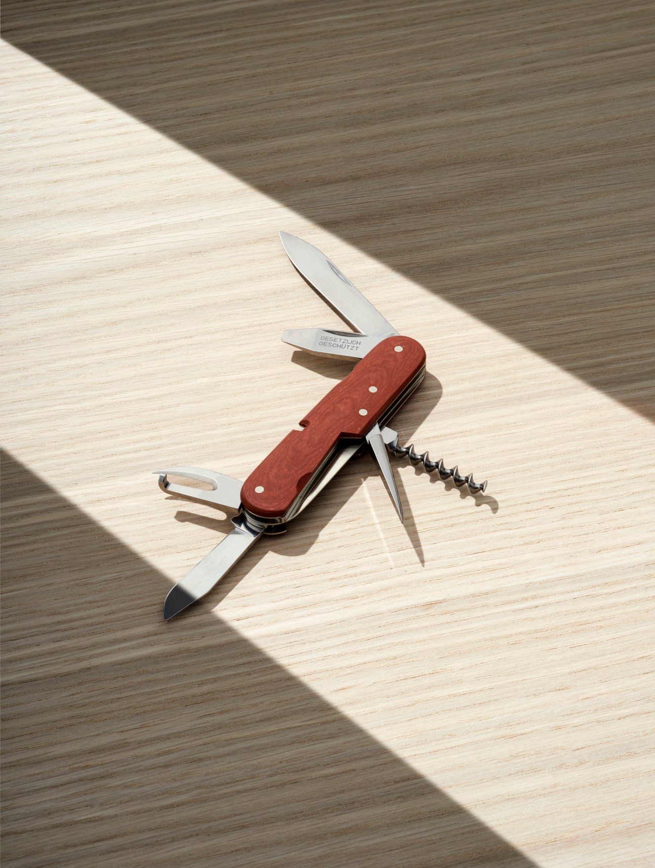 Victorinox Replica 1897 Swiss Army Knife with red handle and multiple tools displayed on wooden surface