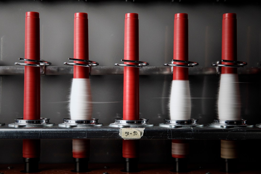Industrial textile manufacturing equipment with spools and machinery in production facility
