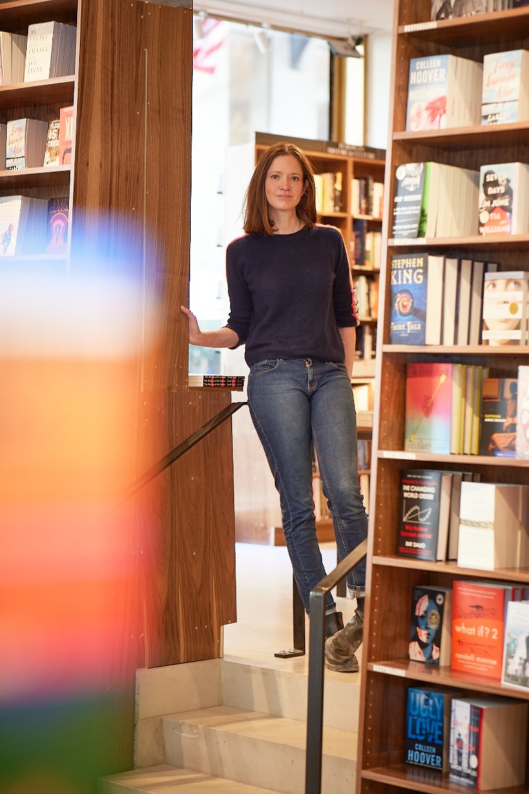 Sarah McNally standing among bookshelves in her bookstore